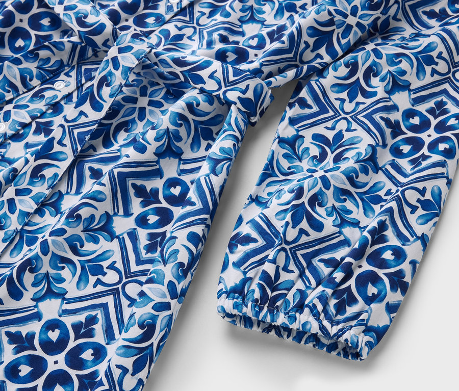 Detailaufnahme eines bedruckten Midi-Kleids in Blau und Weiß.