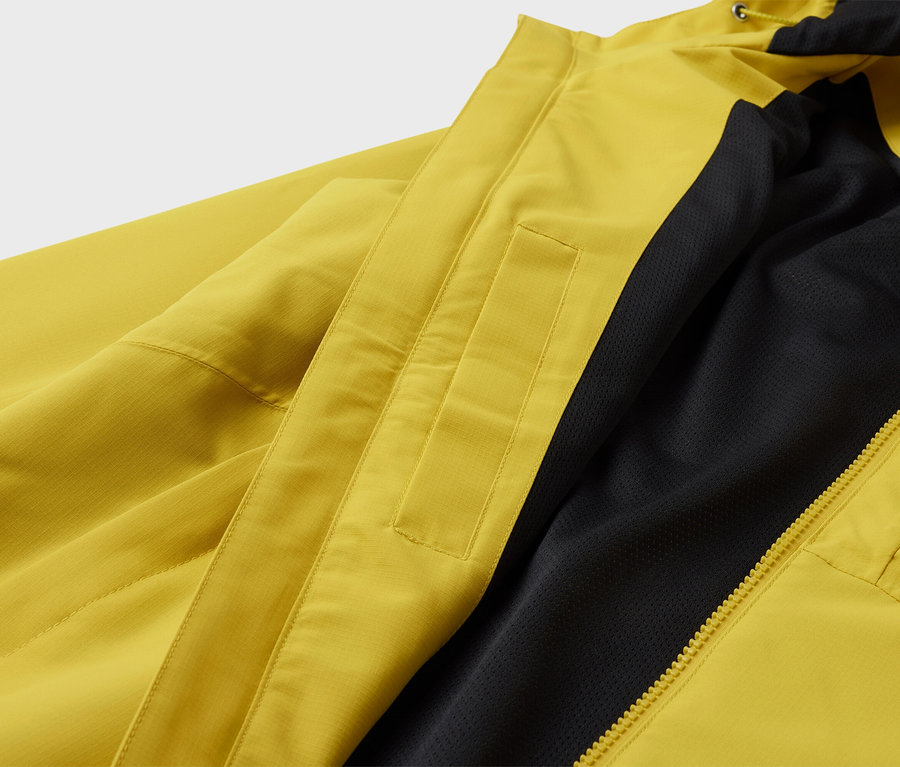 Gelbe Jacke mit schwarzem Futter und Reißverschluss.