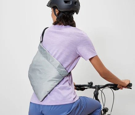 Frau auf einem Fahrrad mit einer Fahrrad-Einkaufstasche.