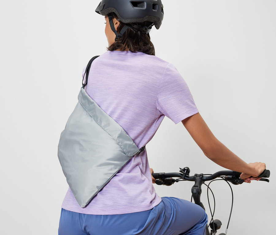 Frau auf einem Fahrrad mit einer Fahrrad-Einkaufstasche.