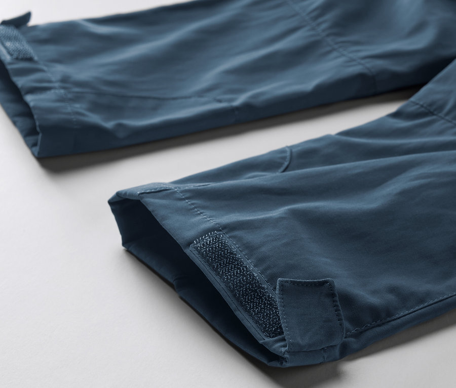 Detailaufnahme der Beinenden einer blauen Kleinkinder-Funktionshose mit Klettverschlussbändern.