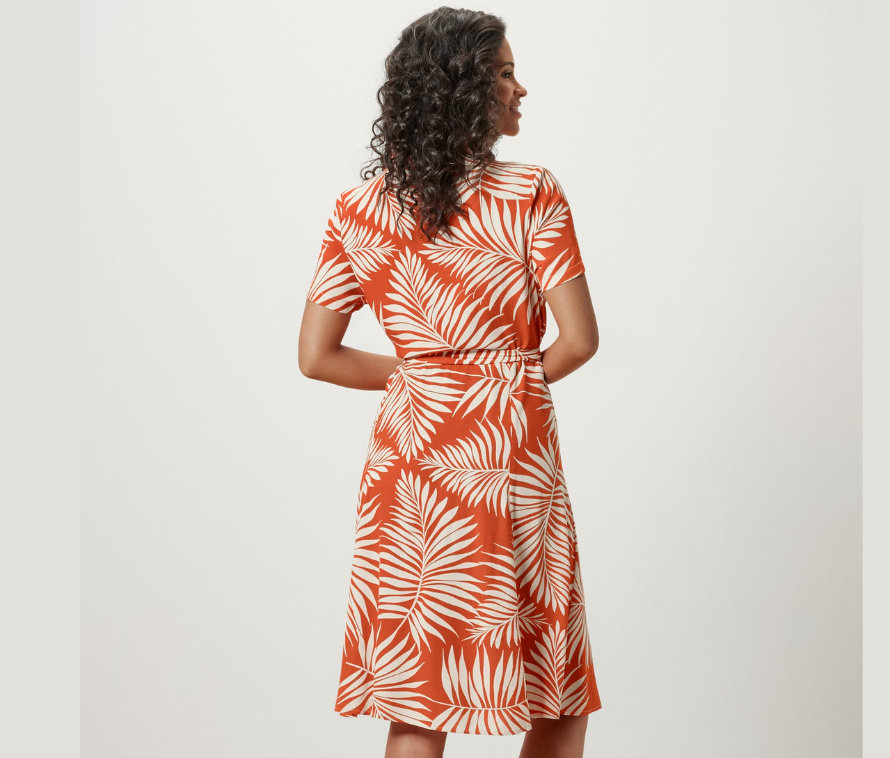 Frau posiert in einem bedruckten Hemdblusenkleid.