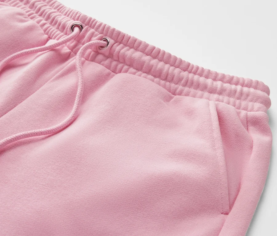 Detail einer rosa Sweathose mit elastischem Bund und Kordelzug.