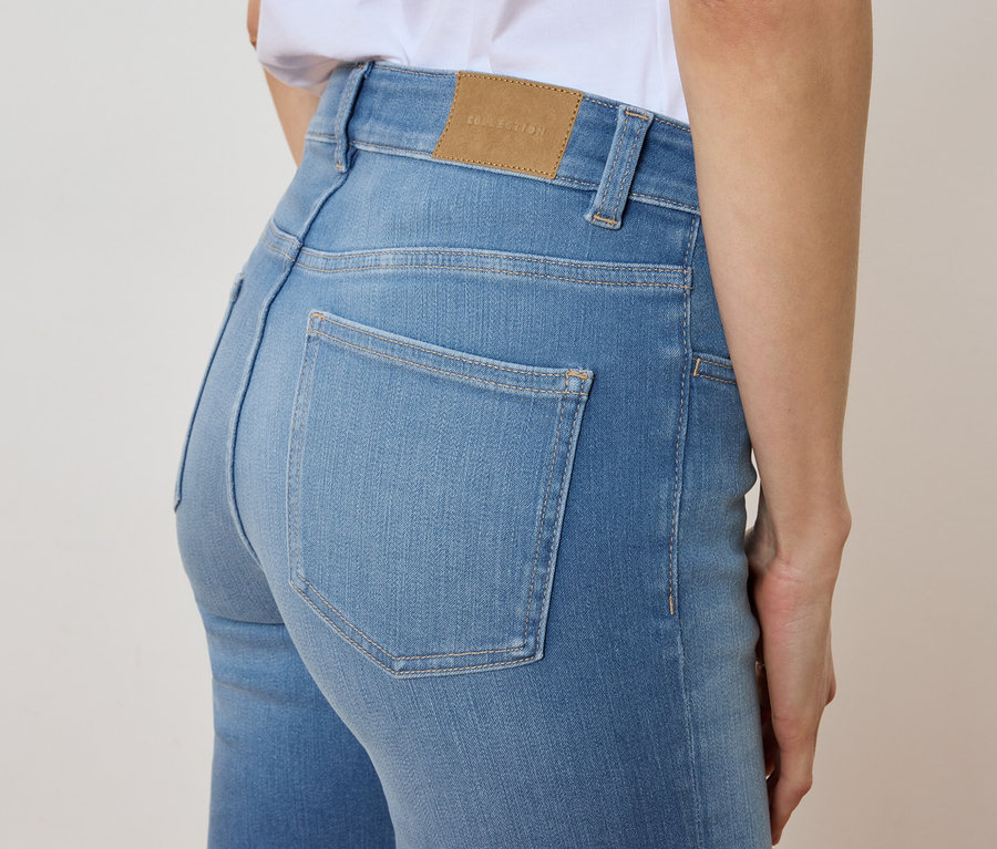 Nahaufnahme einer Frau, die hellblaue Jeans trägt.