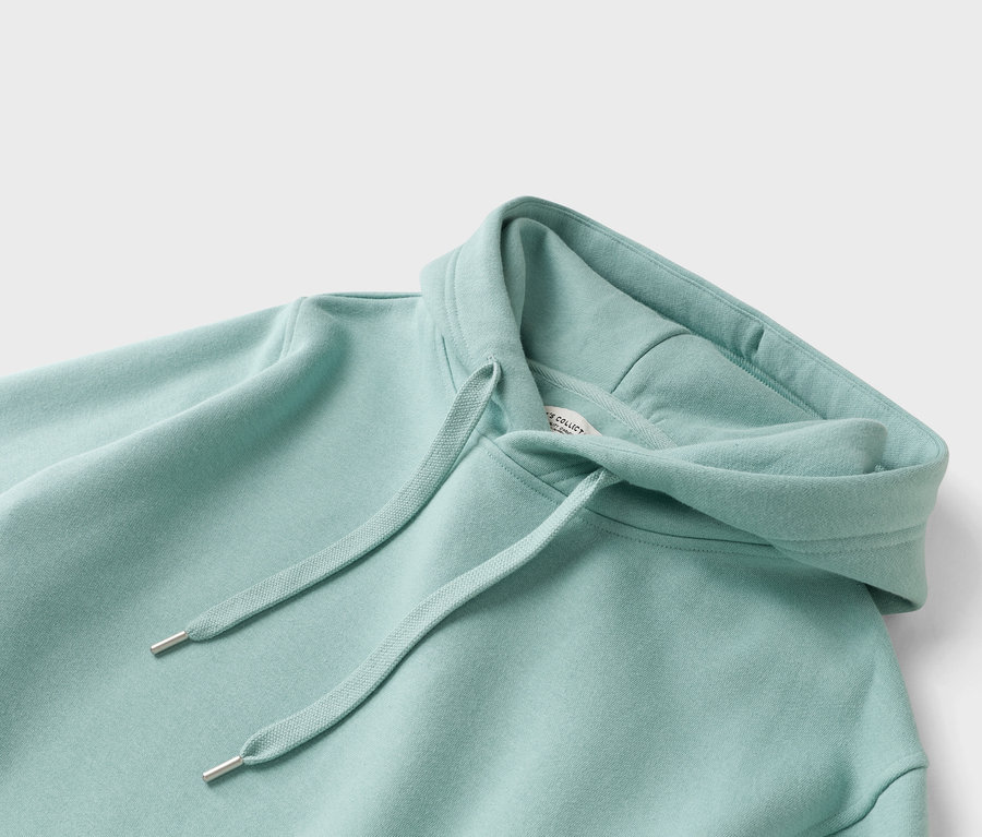 Nahaufnahme eines mintgrünen Hoodies mit Kordelzug.
