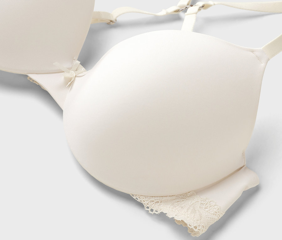 Nahaufnahme eines elfenbeinfarbenen BHs mit Spitze am Unterteil.