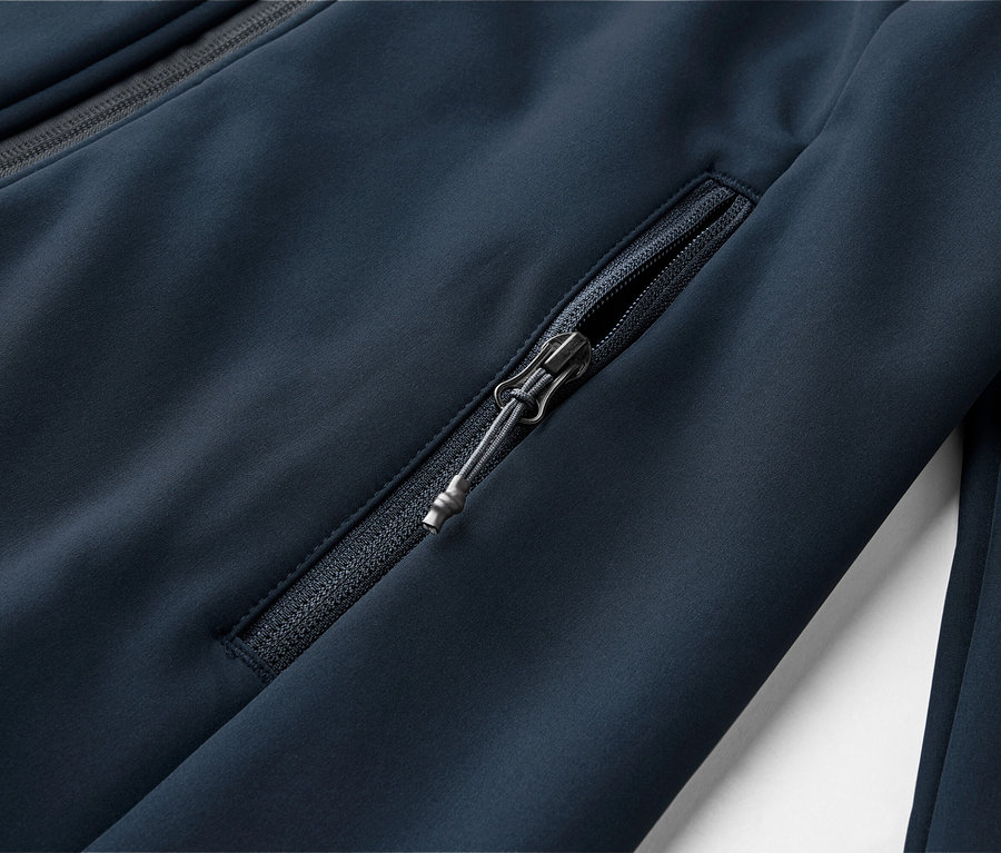 Nahaufnahme einer marineblauen Jacke mit Reißverschlusstasche und einem Reißverschluss am Kragen.