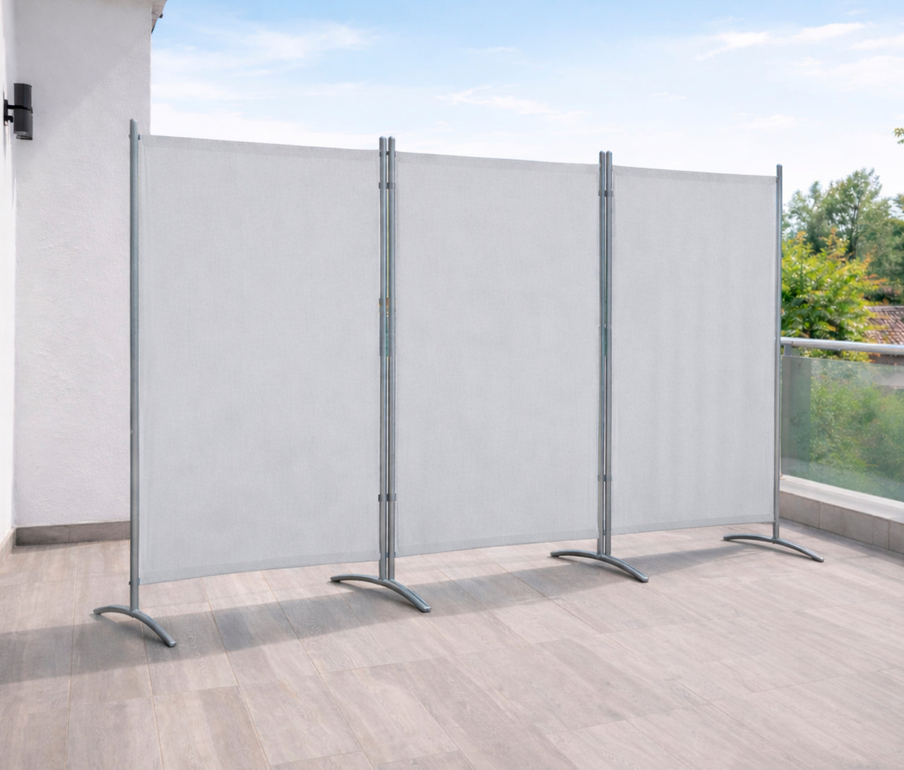 Drei Leco Stellwände, 3-teilig, in Hellgrau stehen auf einem Balkon und dienen als Sichtschutz.