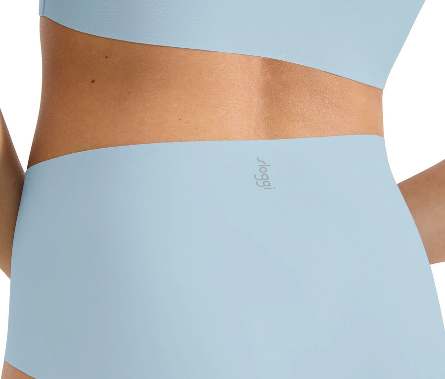 Nahaufnahme der Rückseite einer Frau, die hellblaue Sloggi Unterwäsche und ein passendes Oberteil trägt.