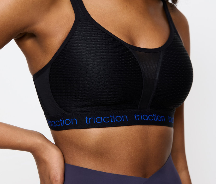 Nahaufnahme einer Frau mit einem schwarzen Triaction Sport-BH und marineblauen Leggings.