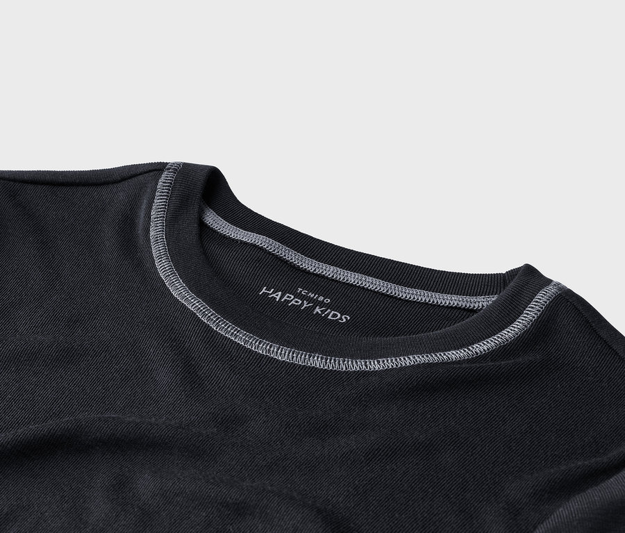 Nahaufnahme eines dunkelgrauen T-Shirts mit weißen Nähten am gerippten Kragen und der Schulternaht. Ein weißes Etikett im Nackenbereich zeigt die Aufschrift "TCHIBO HAPPY KIDS".
