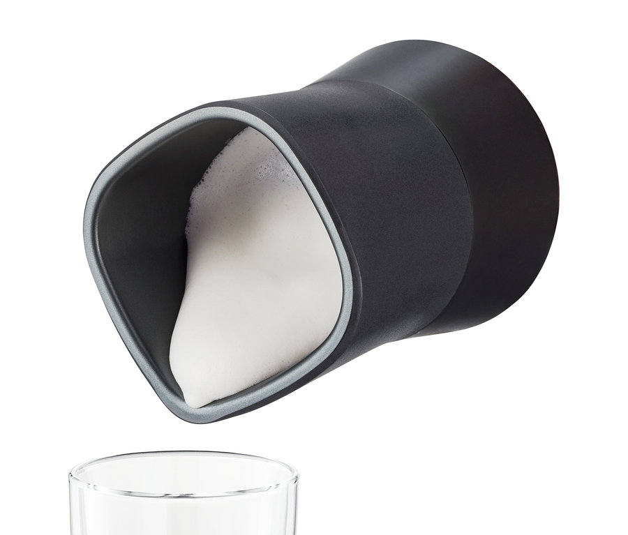 Schwarzer elektrischer Milchaufschäumer gießt Milchschaum in ein Glas.