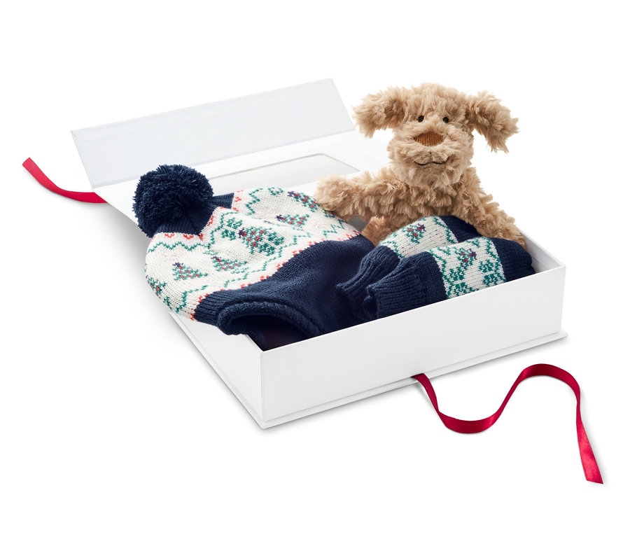 Ein Stoffhund und ein 3-teiliges Baby-Geschenk-Set in einer weißen Geschenkbox.