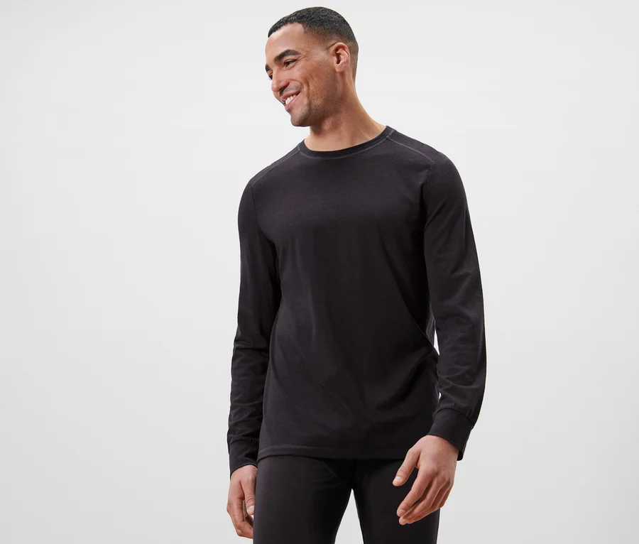 Ein Mann trägt ein schwarzes Langarmshirt mit RWS-zertifizierter Wolle und schaut nach links.