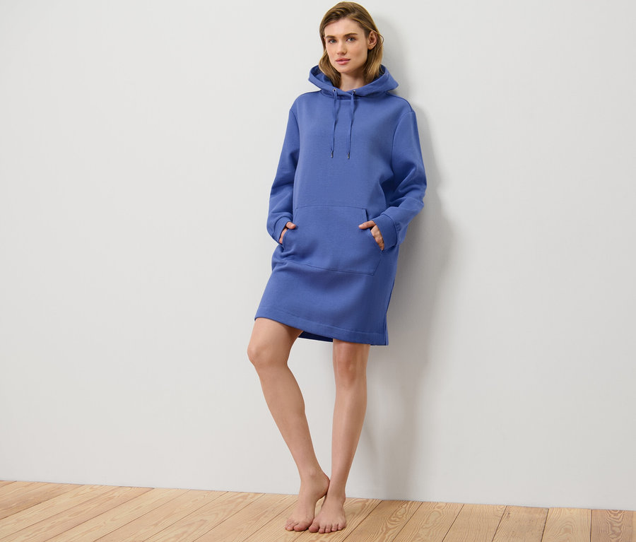 Frau posiert in einem blauen Loungewear-Kleid.