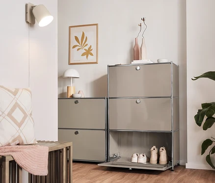 Innenraum mit Ausziehbank, Sideboard Metall »CN3« mit 2 Klappenfächern, Regal Metall »CN3« mit 3 Klappenfächern und cremefarbener Wandleuchte aus Metall.