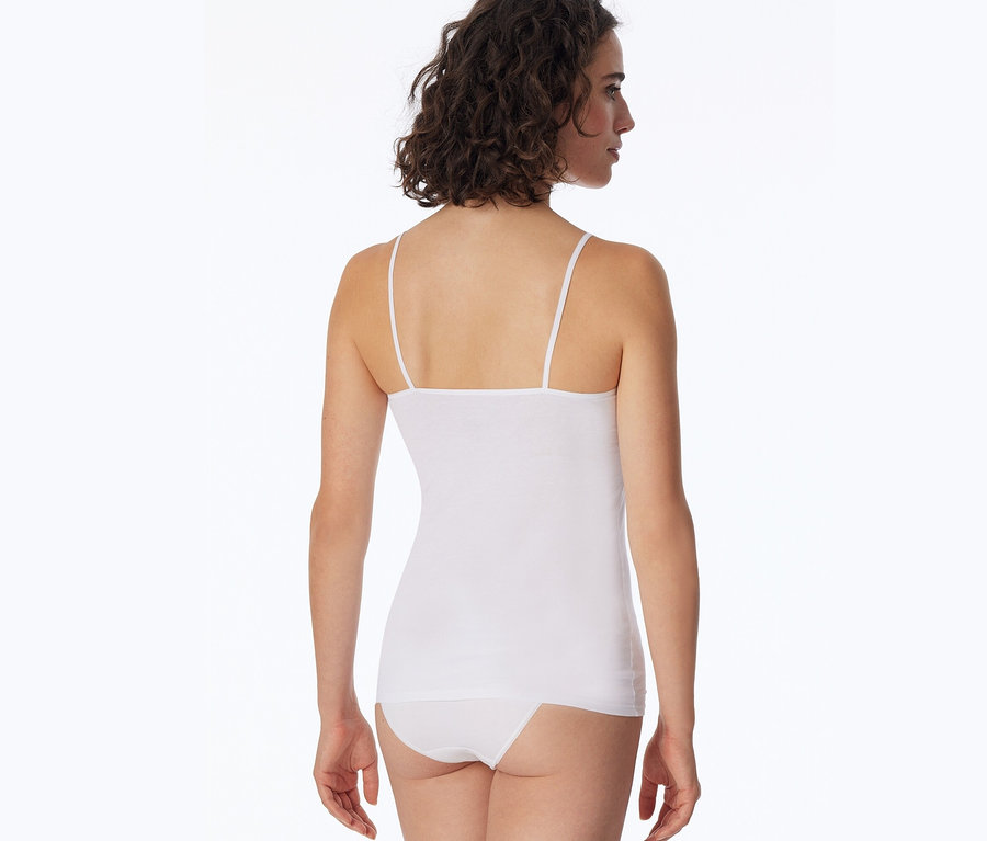 Frau von hinten, leicht gedreht, trägt ein weißes SCHIESSER Top mit dünnen Trägern und einen weißen Slip.