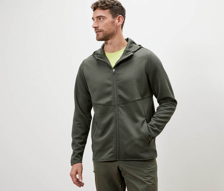 Mann trägt eine khakifarbene Funktionsjacke.