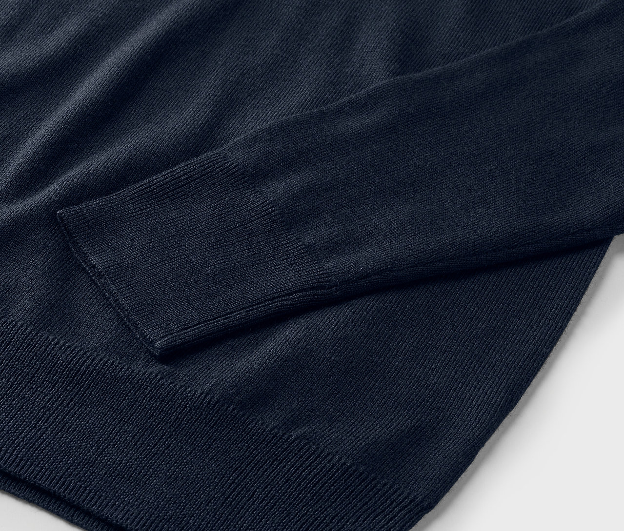 Detailaufnahme eines marineblauen Merino-Feinstrickpullovers.