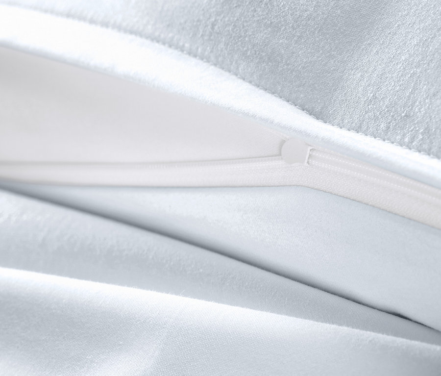 Detailansicht einer weißen Baumwollsatin-Bettwäsche Übergröße mit geöffnetem Reißverschluss.