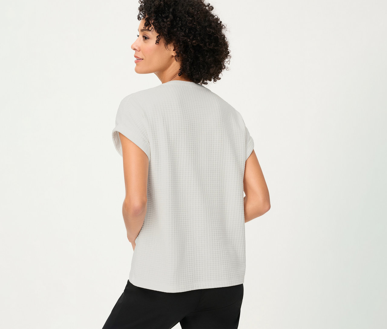 Frau von hinten mit strukturiertem Olsen Shirt mit Knöpfen und schwarzen Hosen.