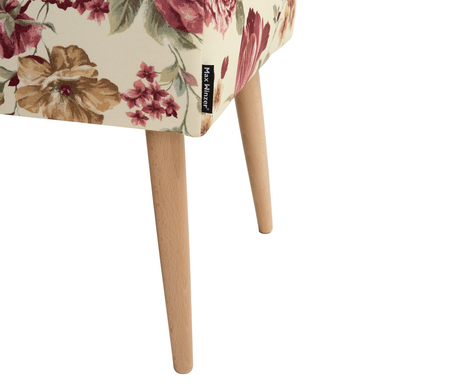 Nahaufnahme eines Hockers mit Blumenmuster und Holzbeinen.