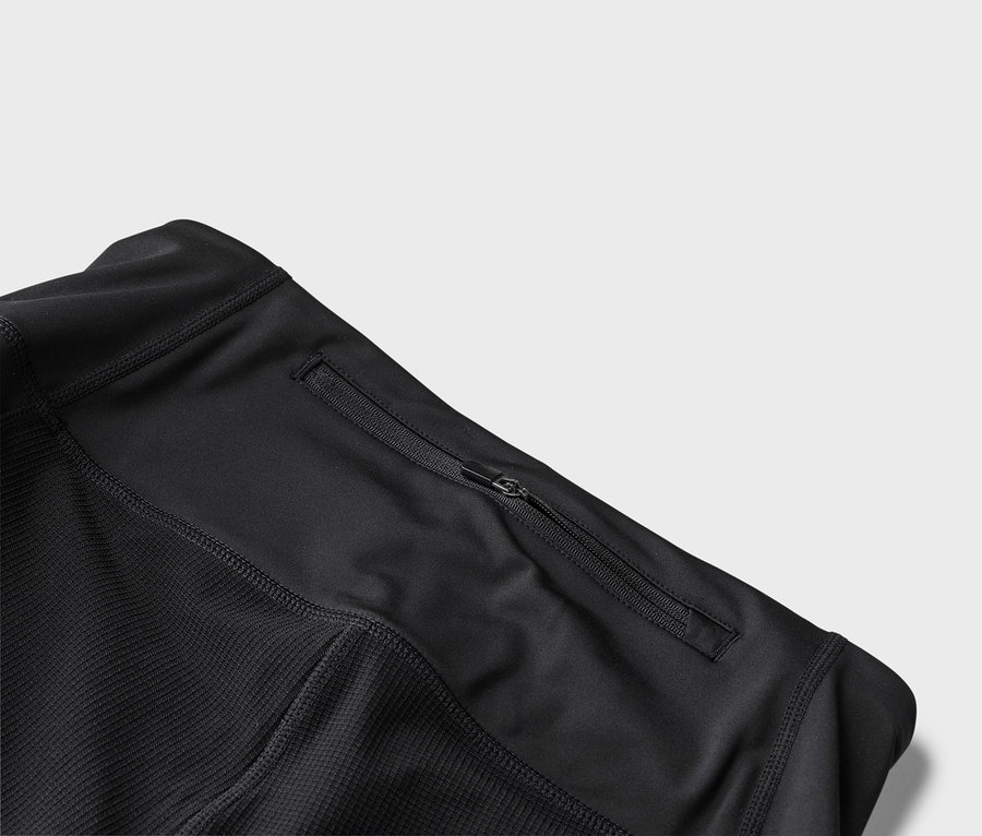 Detailansicht einer schwarzen Sportjacke mit Reißverschlusstasche.