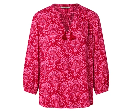 Rote Bluse mit rosa Blumenmuster und Quasten am Halsausschnitt.