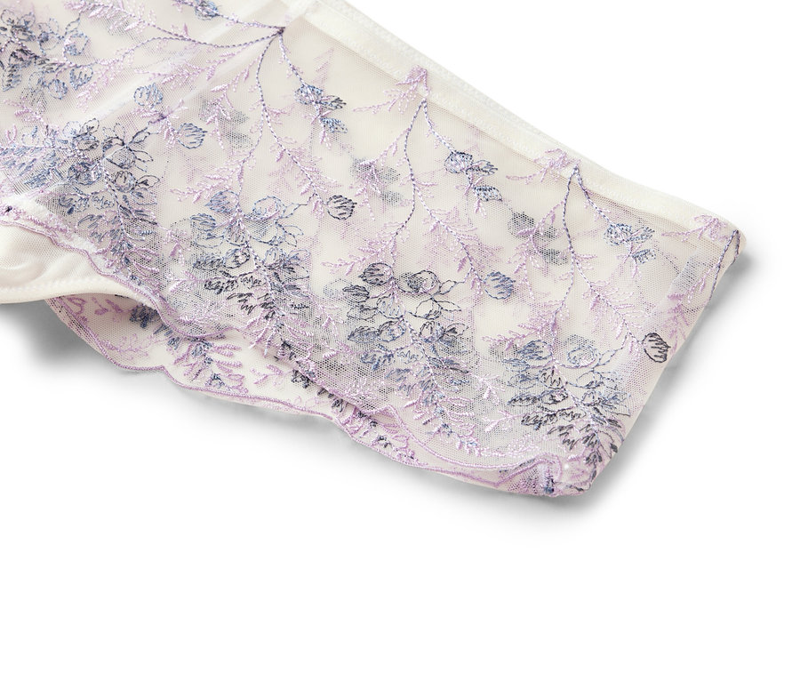 Nahaufnahme eines weißen Spitzenhöschens mit lila und blauen Blumenstickereien.