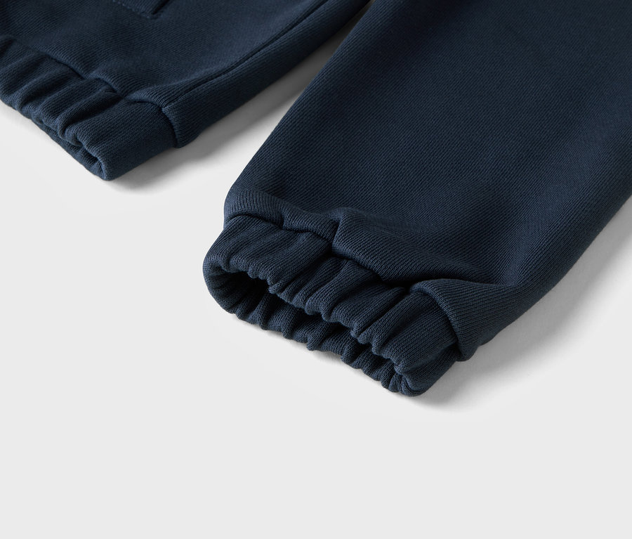 Nahaufnahme von marineblauen Jogginghosen mit gerippten Bündchen.