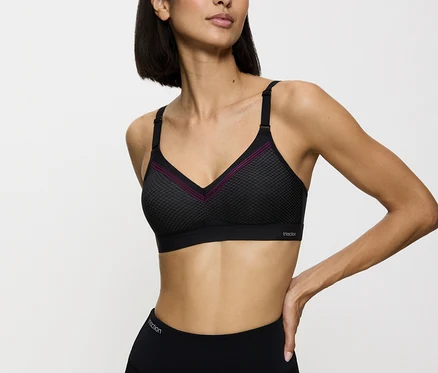 Frau trägt einen schwarzen Sport-BH und Leggings.