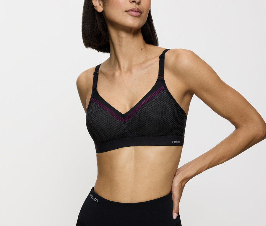 Frau trägt einen schwarzen Sport-BH und Leggings.