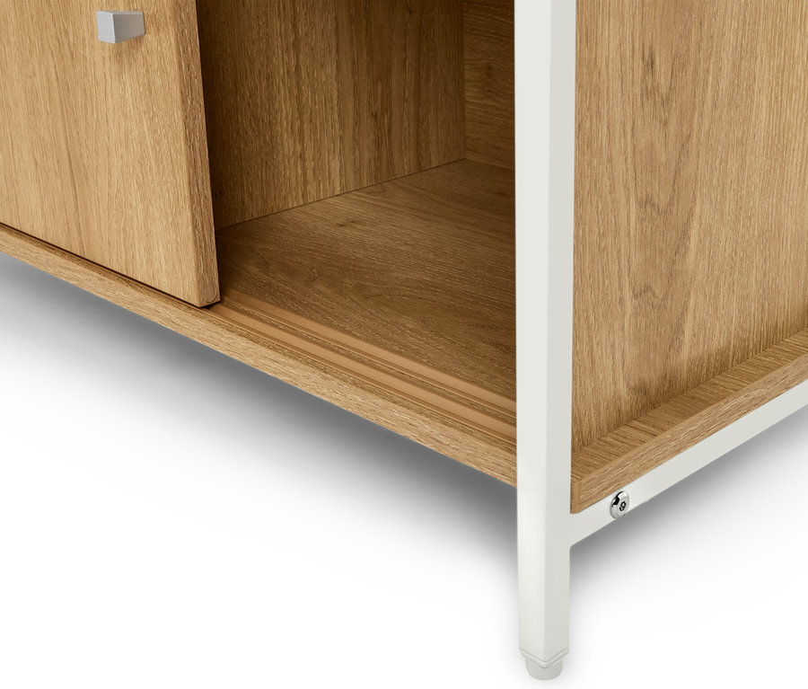 Detailansicht eines hellbraunen Holzschranks mit weißen Beinen.