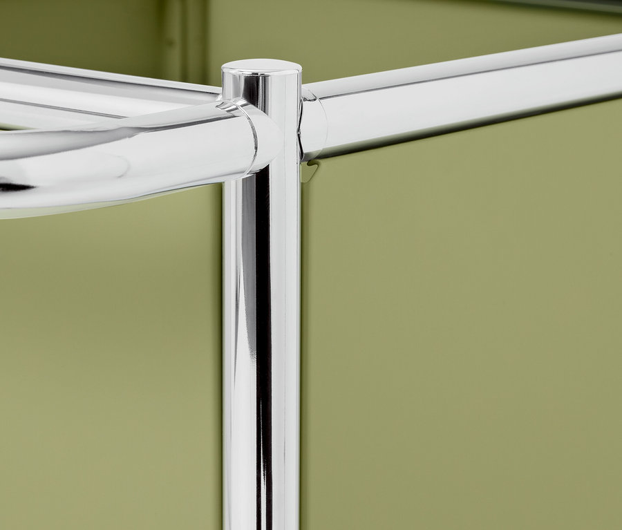 Detailansicht eines verchromten Metallregals vor einem olivgrünen Hintergrund.