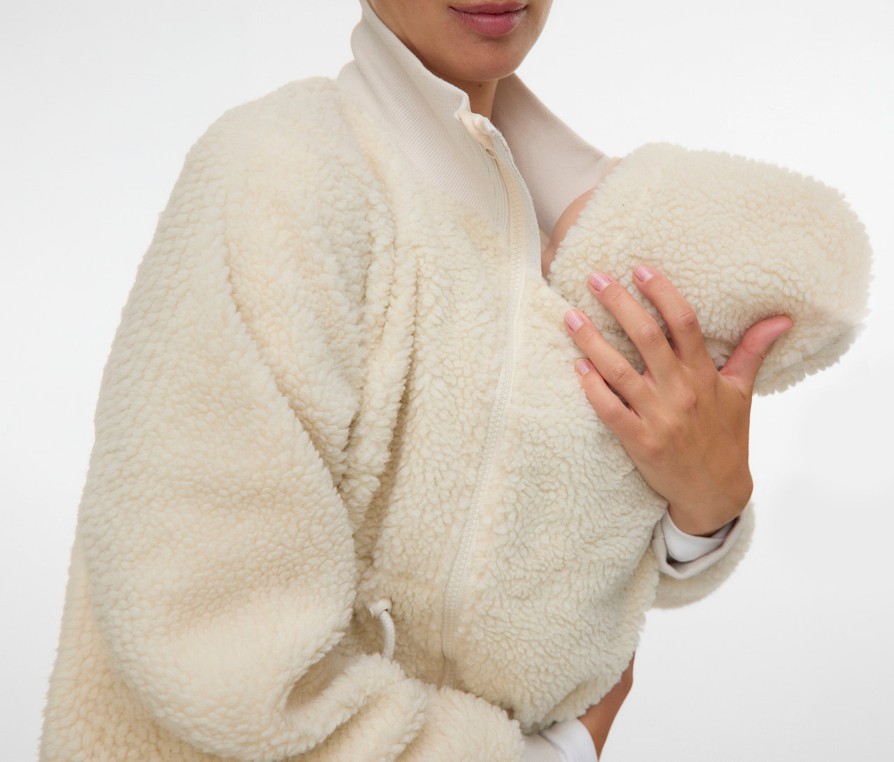 Frau hält Baby in der beigen MAMALICIOUS 3-in-1-Teddyjacke »MLCARLY« mit Reißverschluss.