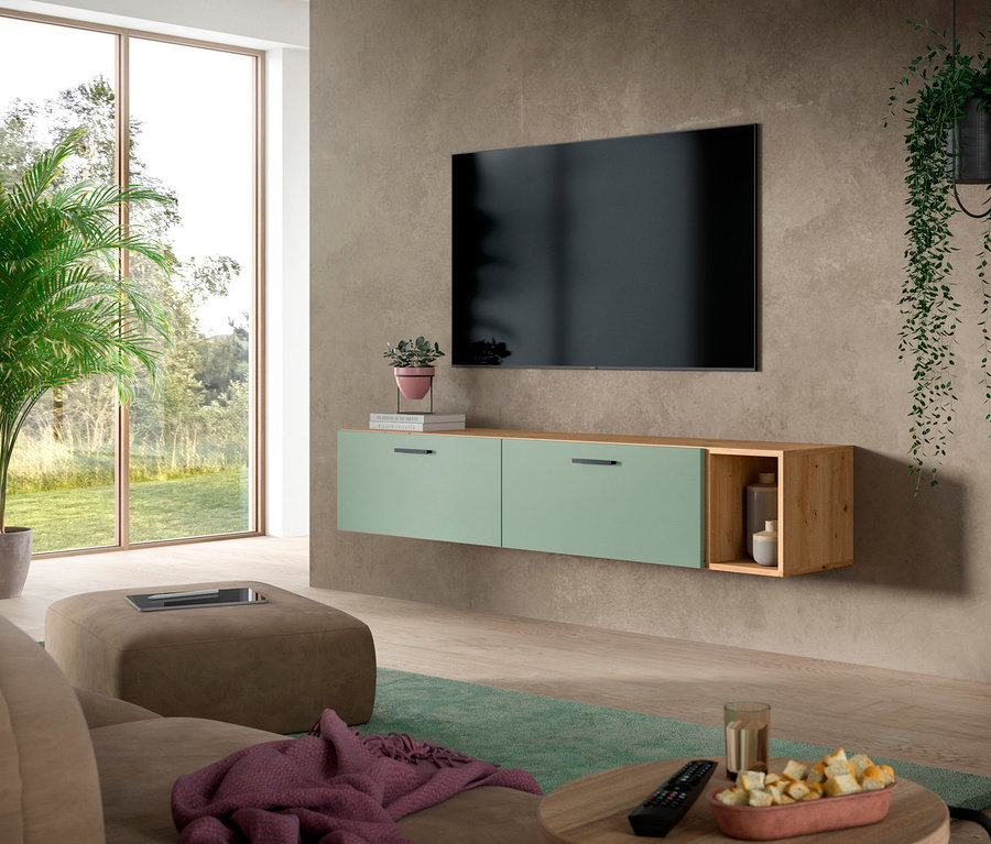 Modernes Wohnzimmer mit großem Fernseher an grauer Wand über einer grünen xonox Wohnwand »The One«. Die Wohnwand hat zwei grüne Schubladen und ein offenes Holzregal. Im Vordergrund stehen ein braunes Sofa, ein Ottoman und ein runder Couchtisch mit Snacks.
