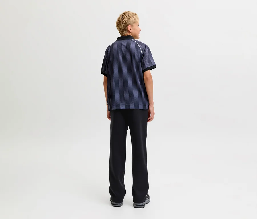 Person von hinten in einem dunkel gestreiften Kurzarmshirt und einer schwarzen Jack&Jones Bradley Sweatpants.