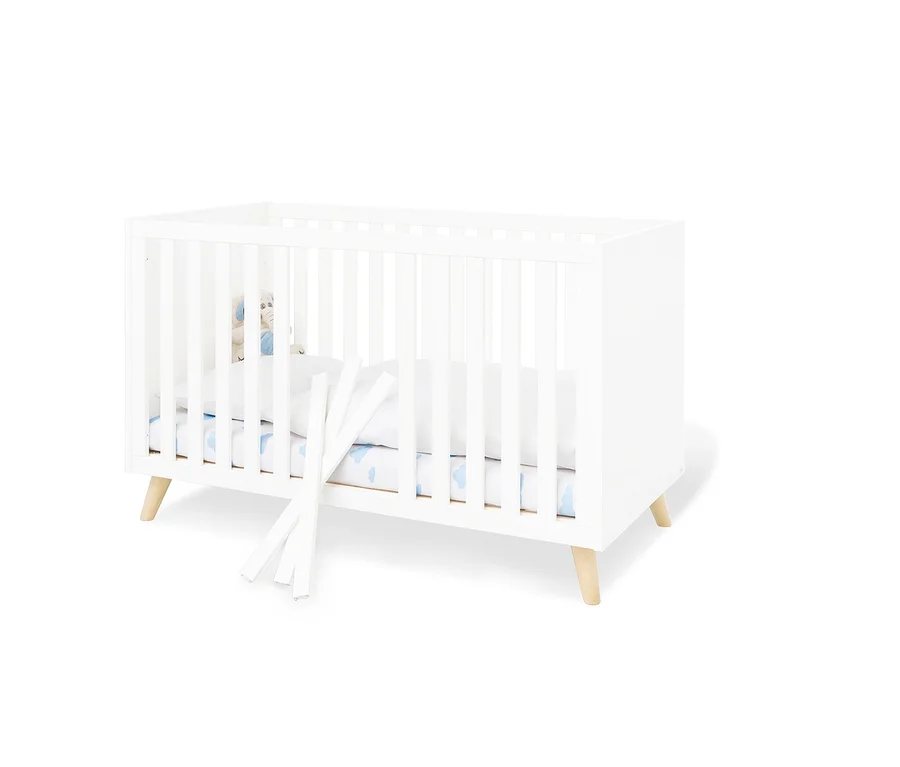 Weißes Pinolino Babybett »Move« mit weißen Seitenteilen und Holzbeinen.