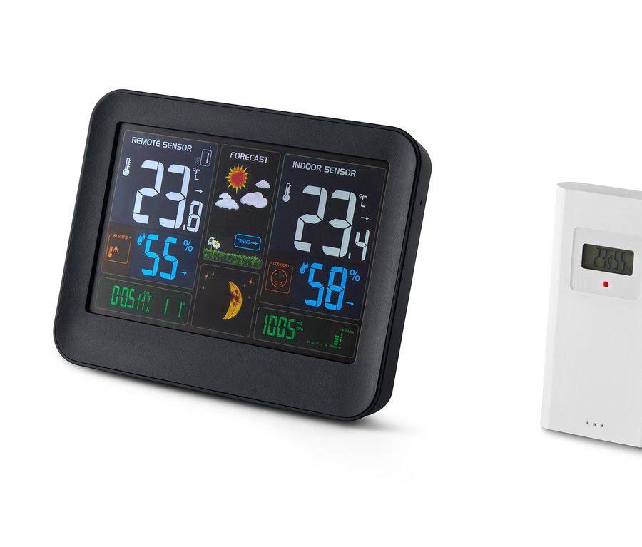 Eine schwarze Funk-Wetterstation mit LC-Farbdisplay zeigt Innen- und Außentemperatur, Luftfeuchtigkeit und Wettervorhersage an. Daneben befindet sich ein weisser Funksensor.