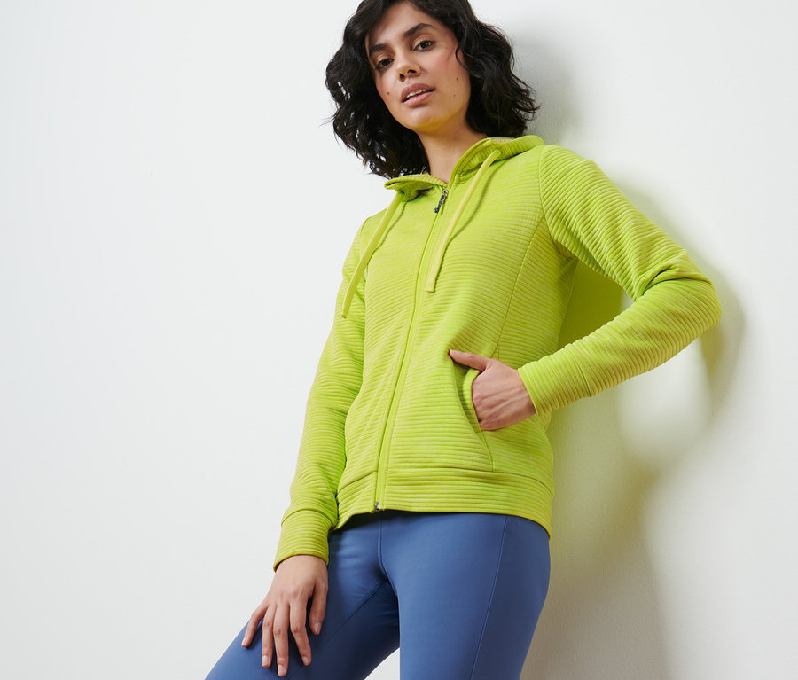 Frau posiert in lime Kapuzenjacke.