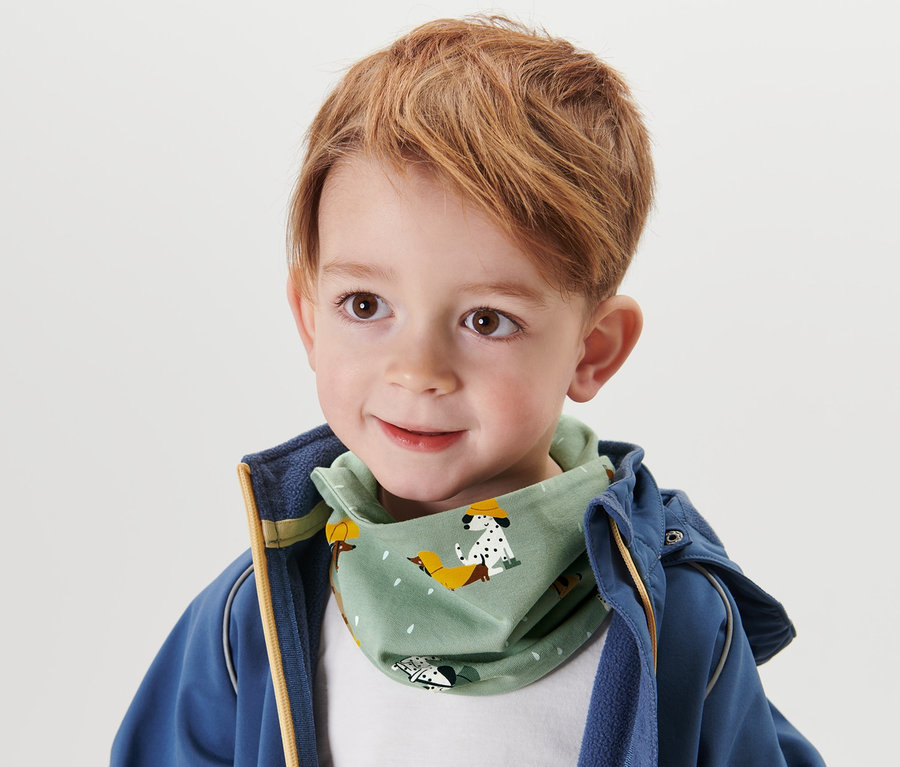 Kleiner Junge mit braunen Haaren und einem Kinder-Halstuch mit Klett.