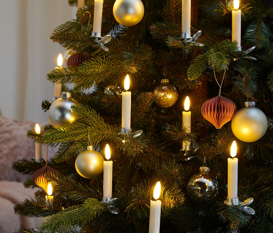Detailaufnahme eines Weihnachtsbaums geschmückt mit cremefarbigen 12 LED-Weihnachtsbaumkerzen und Christbaumkugeln.