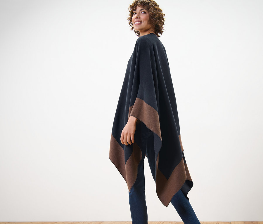 Frau posiert in einem Wende-Poncho.