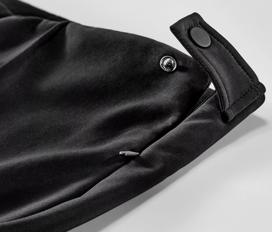Detail einer Softshell-Ski-Tight mit Reißverschlusstasche und Druckknopfverschluss.