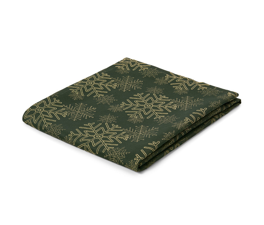 Eine grüne Jacquard-Tischdecke mit Schneeflockenmuster, gefaltet auf einem weißen Hintergrund.