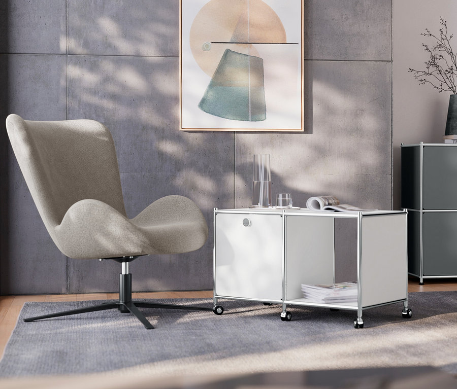 Im Wohnzimmer steht ein Drehsessel neben einem weißen Beistelltisch Metall »CN3« mit 1 Klappenfach und Rollen. Im Hintergrund befindet sich ein graues Sideboard Metall »CN3« mit 2 Klappenfächern und eine Tischleuchte aus Metall, verchromt.