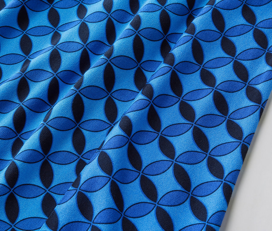 Detailansicht eines dunkelblauen, bedruckten Midirocks.