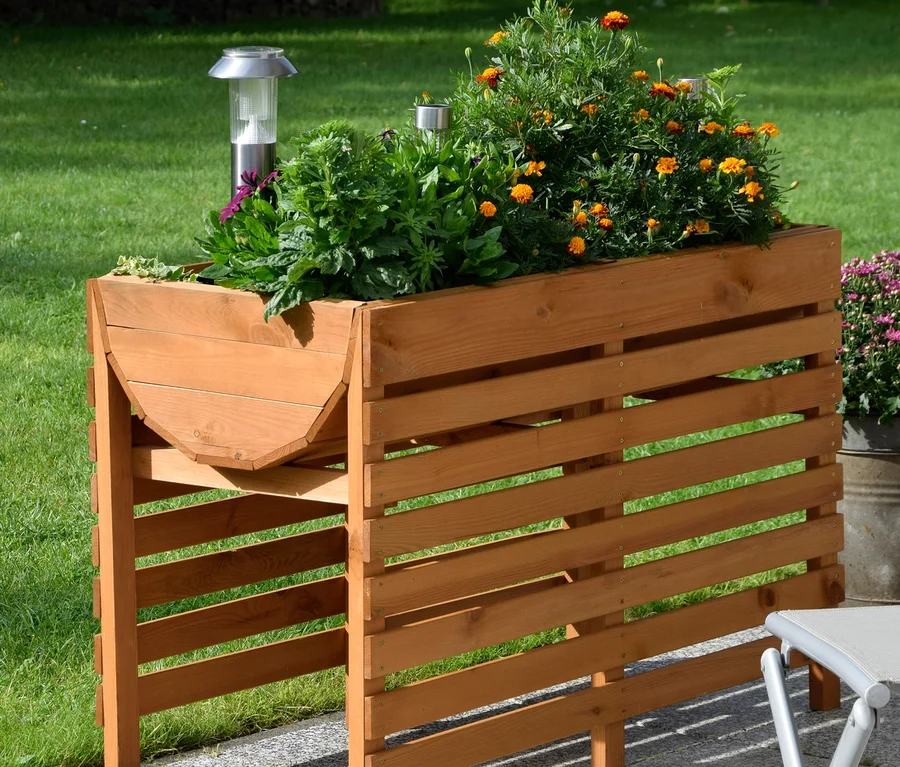 Ein braunes, doppeltes XL-Hochbeet mit Pflanzen und einer Solarleuchte steht auf einer Terrasse.