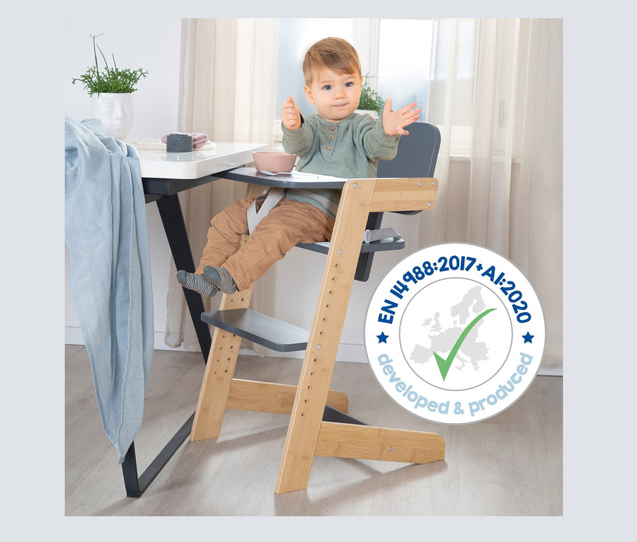 Baby sitzt im anthrazitfarbenen roba Kinderhochstuhl am Tisch.