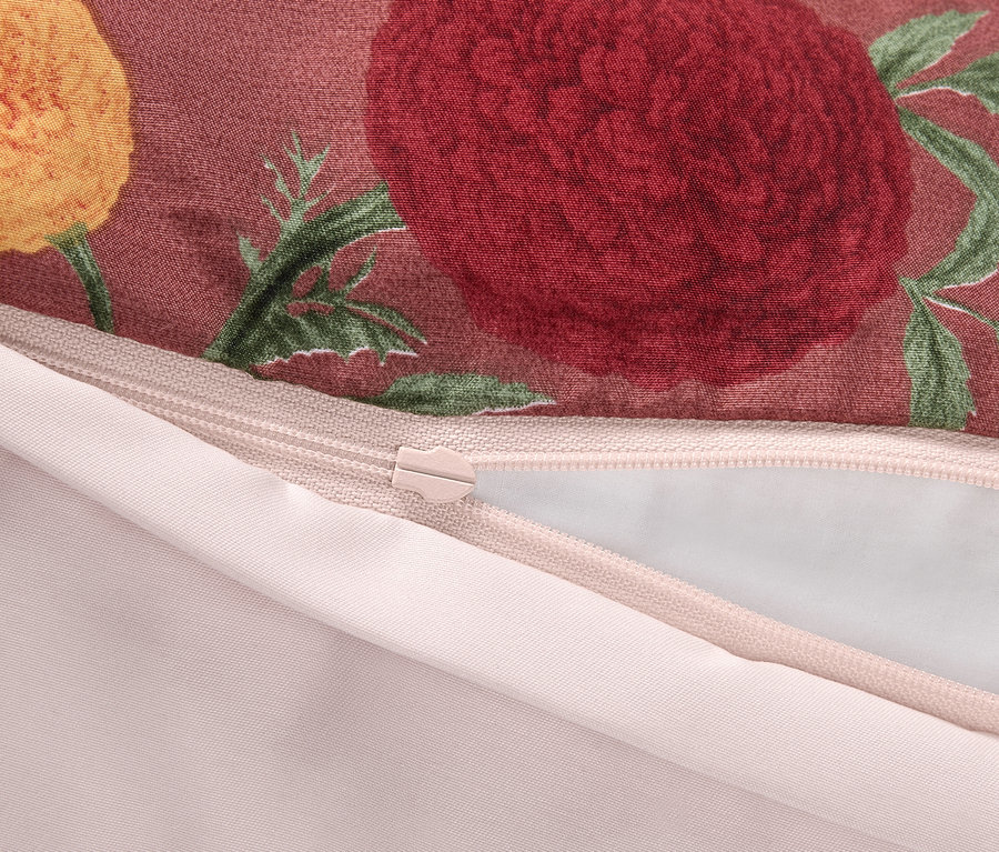 Detail eines Reißverschlusses auf einem Kissenbezug mit Blumenmuster.